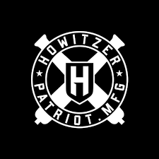 Circular black and white logo with HOWITZER PATRIOT MFG text, a shield with an H in the center, and crossed cannon designs in the background.