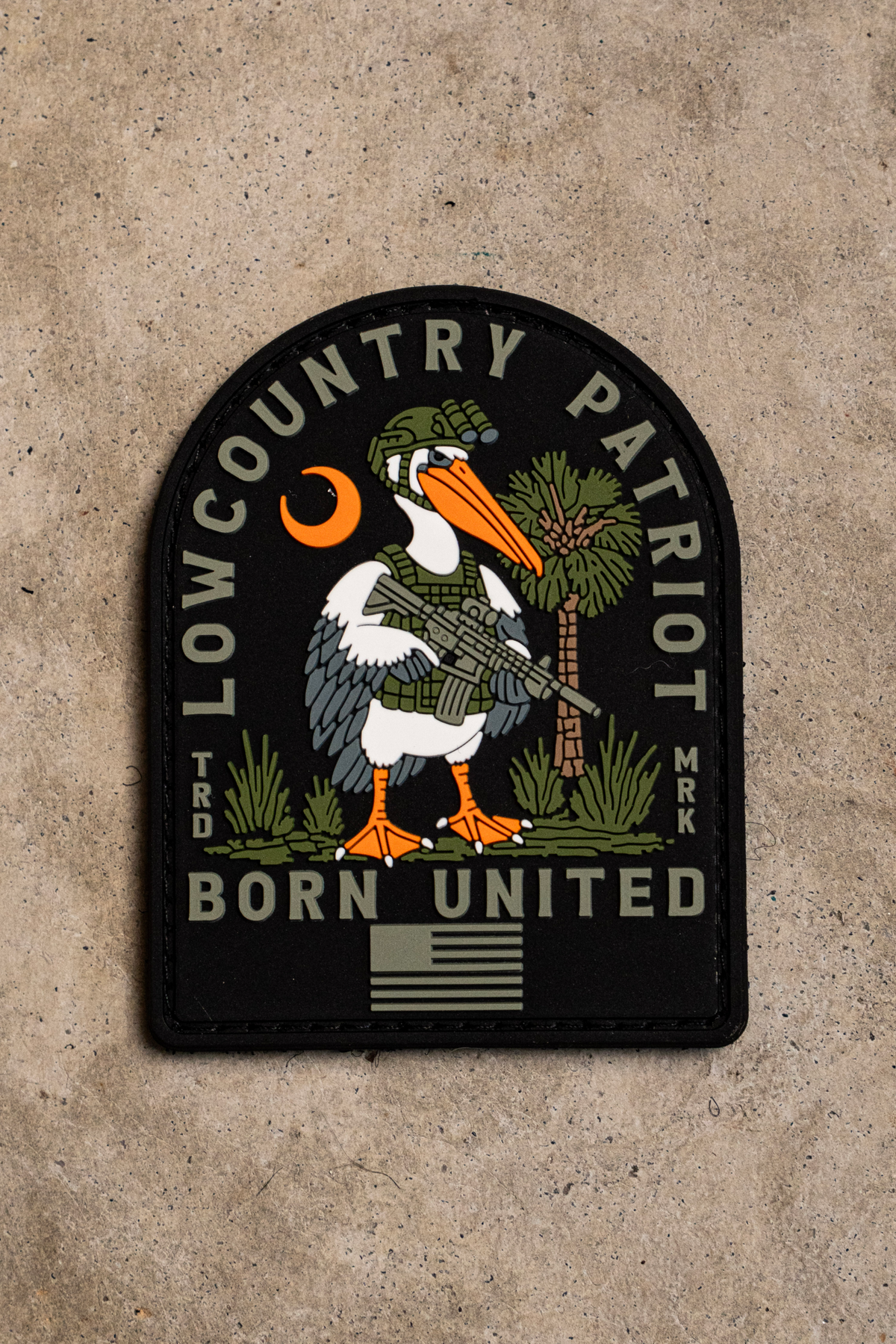 Lowcountry Patriot PVC Patch featuring a 3D cartoon pelican in tactical gear holding a rifle, with LOWCOUNTRY PATRIOT and BORN UNITED text above and below the image.