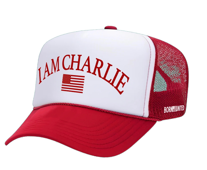 The I Am Charlie Red Trucker Snapback by Born United Private Label features a red and white flat bill, "I AM CHARLIE" in red above a small American flag, a breathable red mesh snapback, and "BORN UNITED" in white on the side.