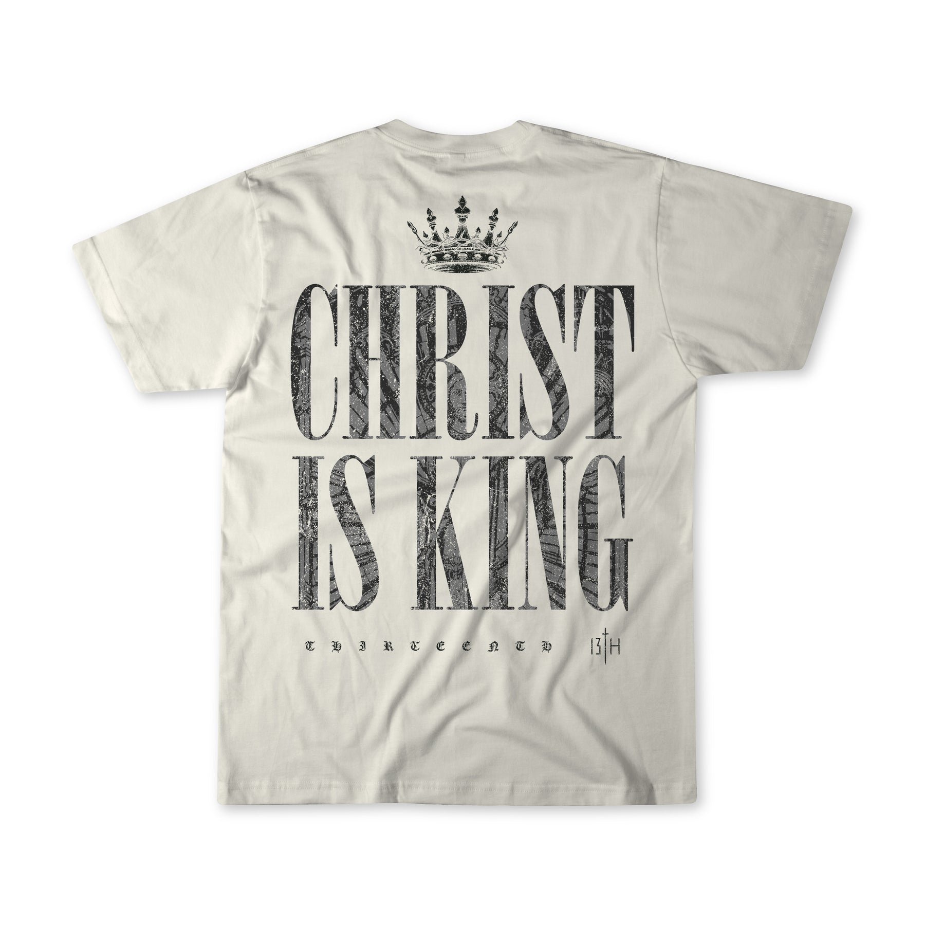 The Christ is King - Ivory T-shirt by 13th features a crown graphic above bold CHRIST IS KING text with THIRTEENTH 13|H below—a premium tee perfect for making a faith-filled statement.