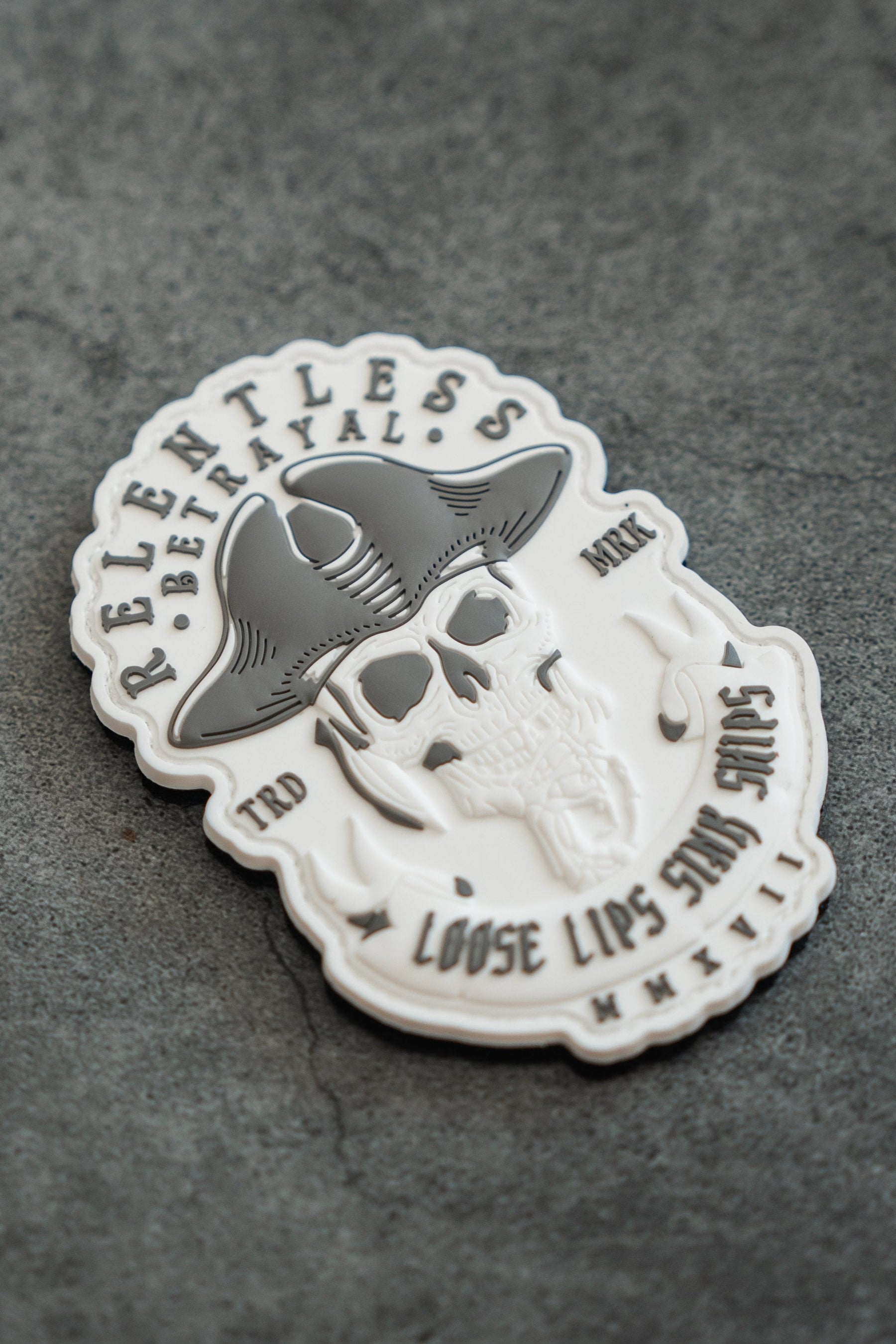 The Loose Lips Sink Ships PVC Patch by Relentless Betrayal is a white and gray 3D design featuring a skull with a cowboy hat, RELENTLESS, BETRAYAL, WWII-era phrase LOOSE LIPS SINK SHIPS, and the Roman numerals MMXVII on a textured gray background.