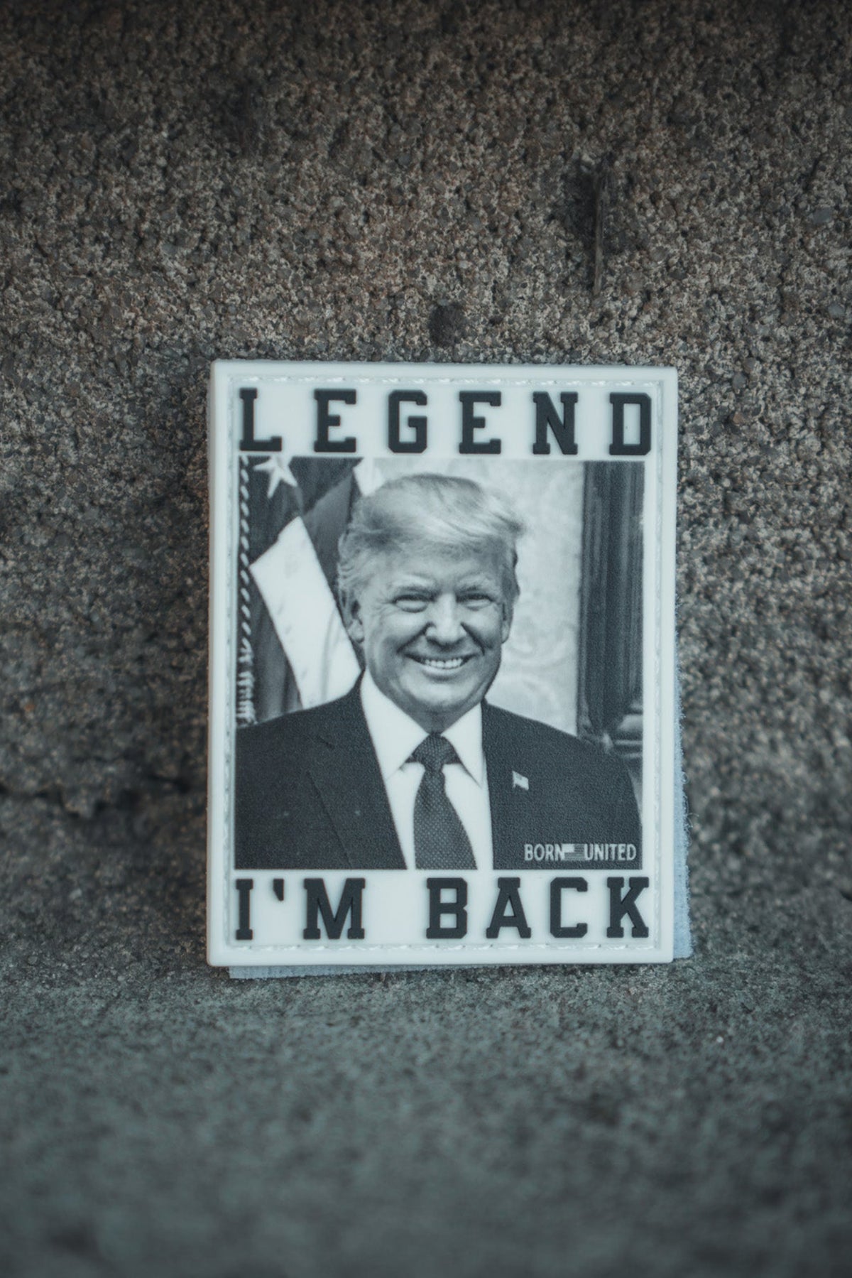 The I’m Back PVC Patch by Born United Private Label features a black-and-white photo of a smiling man in a suit, with “LEGEND” at the top and “IM BACK” at the bottom—a commemorative patch resembling President Trump 2024.