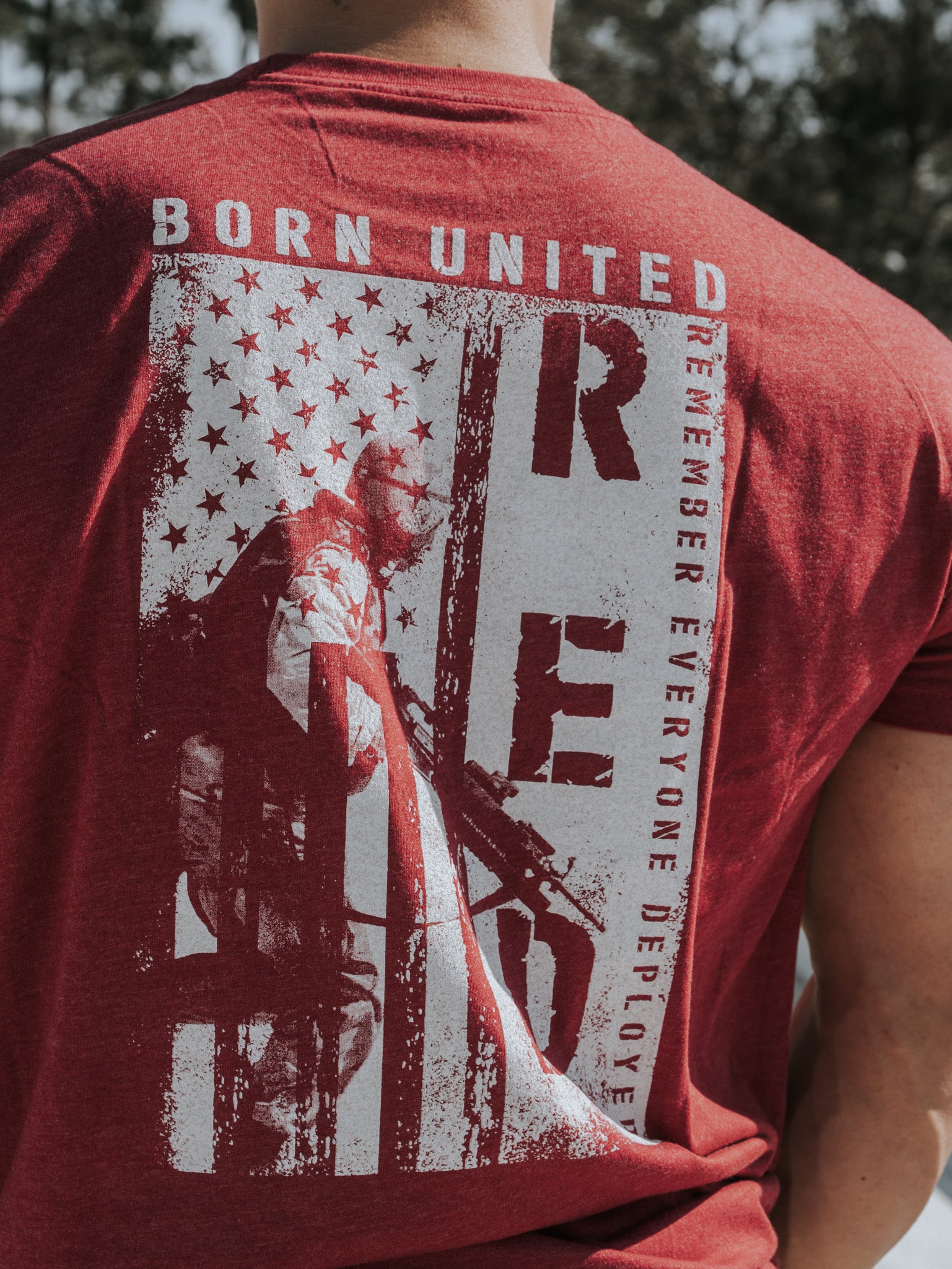 Wearing the R.E.D. Friday red shirt from Born United Private Label showcases a stylized American flag and soldier design featuring BORN UNITED and RED, which stands for Remember Everyone Deployed, honoring the brave soldiers who defend our freedoms.
