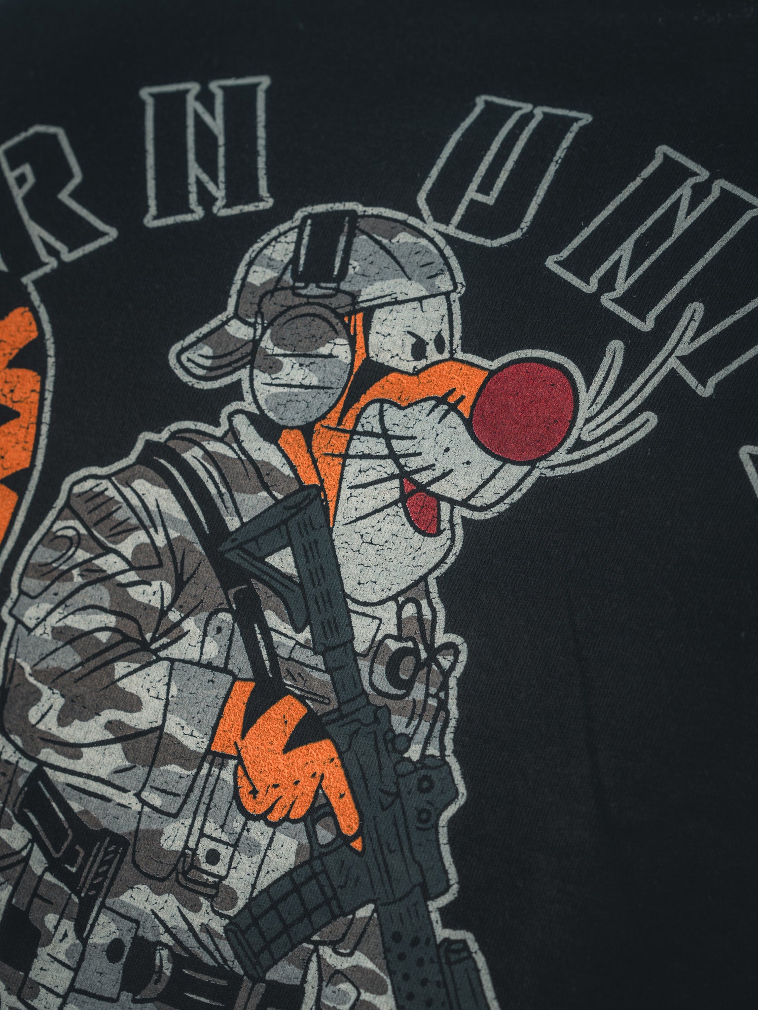 Cartoon character with orange fur and a red nose, dressed as a patriot in helmet and camo uniform, holding a rifle. Text above on dark background. Product: Triggered - Black Tee by Born United Private Label.