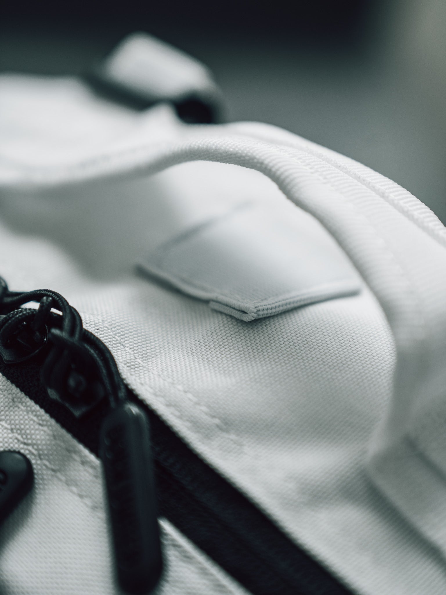 Close-up of the Born United Private Label Storm Trooper Tac-Pac - 45L, a white fabric bag with black zipper and handle, featuring textured material and stitching. The Star Wars-inspired design captures Stormtrooper elegance in every detail.