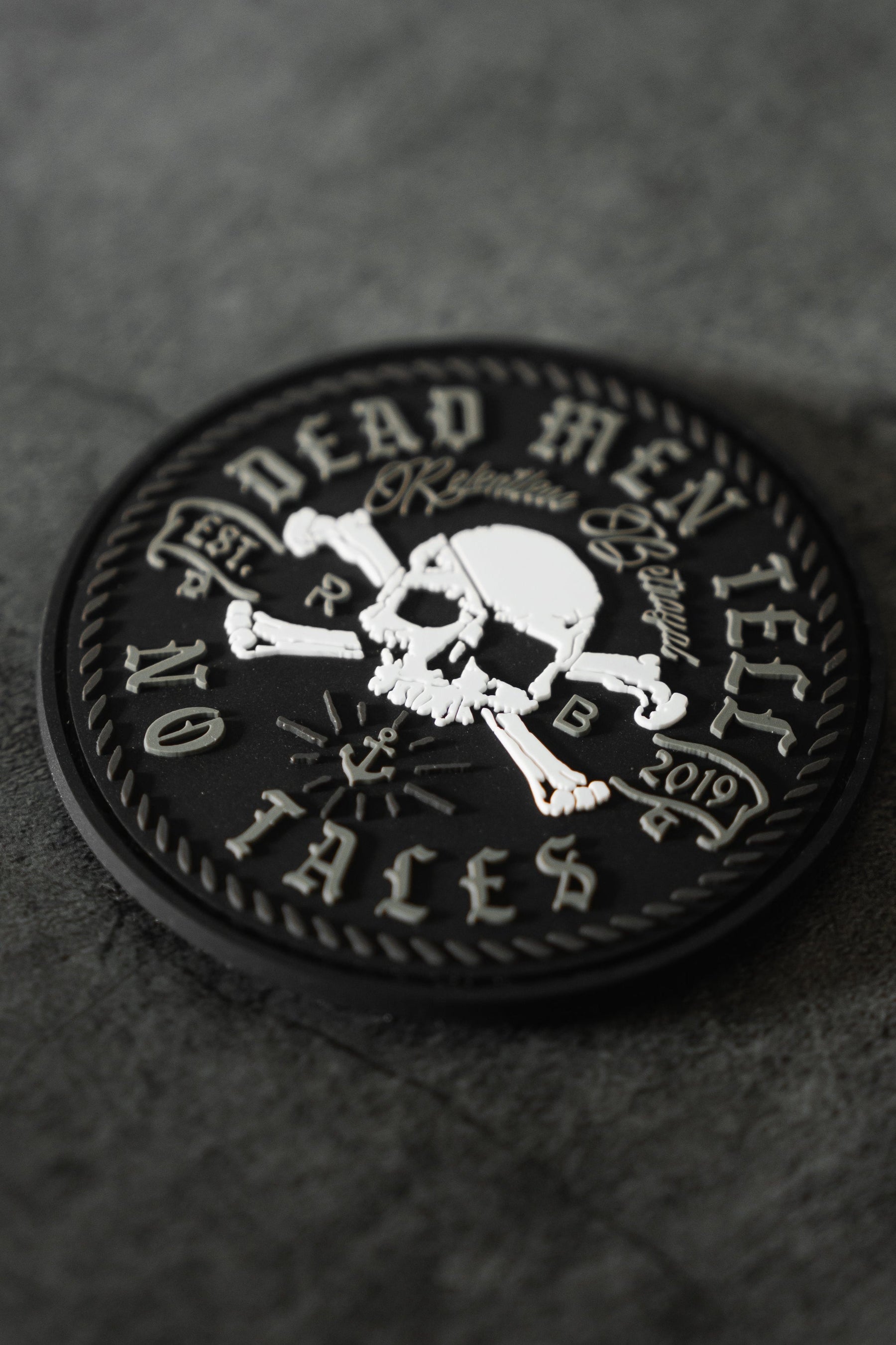 The Tell No Tales Patch by Relentless Betrayal features a bold white skull and crossbones with the phrase Dead Men Tell No Tales, Est. 2019, and Ralphus. This 3D PVC patch adds pirate flair, perfect for pairing with a premium t-shirt.