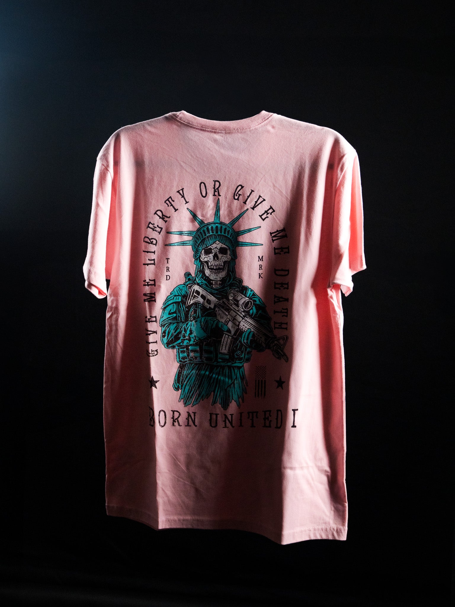 The Liberty Or Death- Heather Pink t-shirt by Born United Private Label features a skeletal Statue of Liberty with rifle and bold “Give Liberty Or Give Me Death” text—a striking, patriotic statement piece against a dark background.