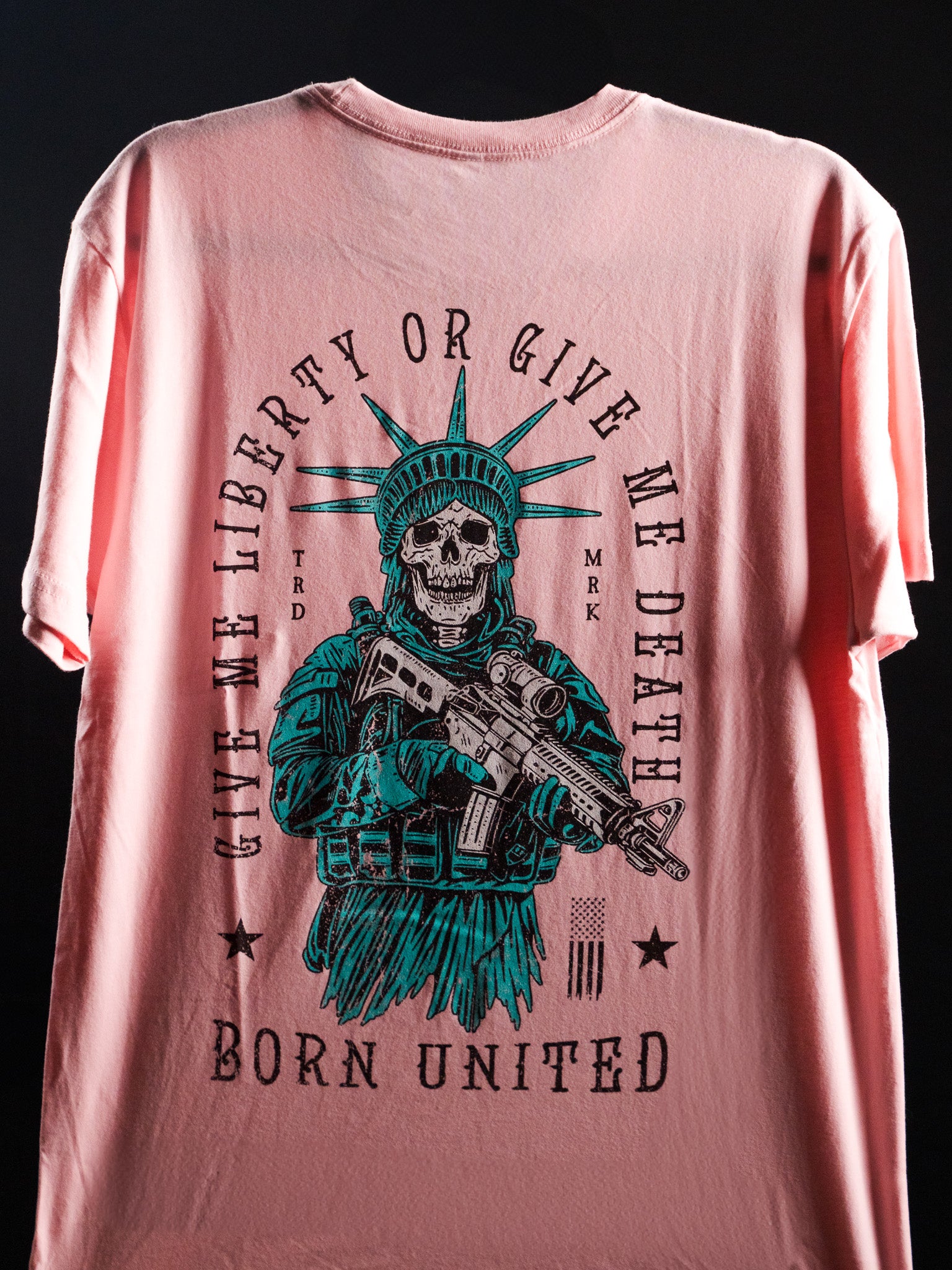 Show your patriotism with the Liberty Or Death- Heather Pink tee by Born United Private Label, featuring a skeleton Statue of Liberty holding a rifle and Give Me Liberty Or Give Me Death print.