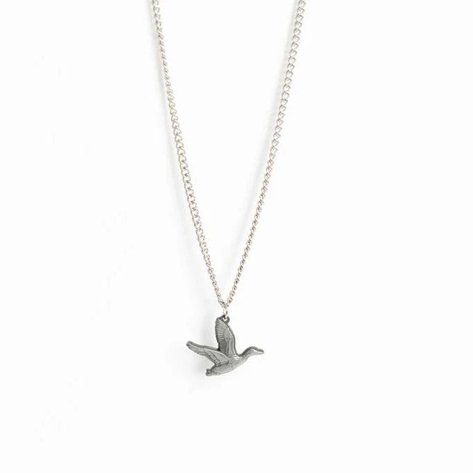 The Mucker Bucket Duck It Silver Necklace features a detailed stainless steel flying duck pendant with outstretched wings on a delicate chain, elegantly set against a plain white background. Made in the USA.