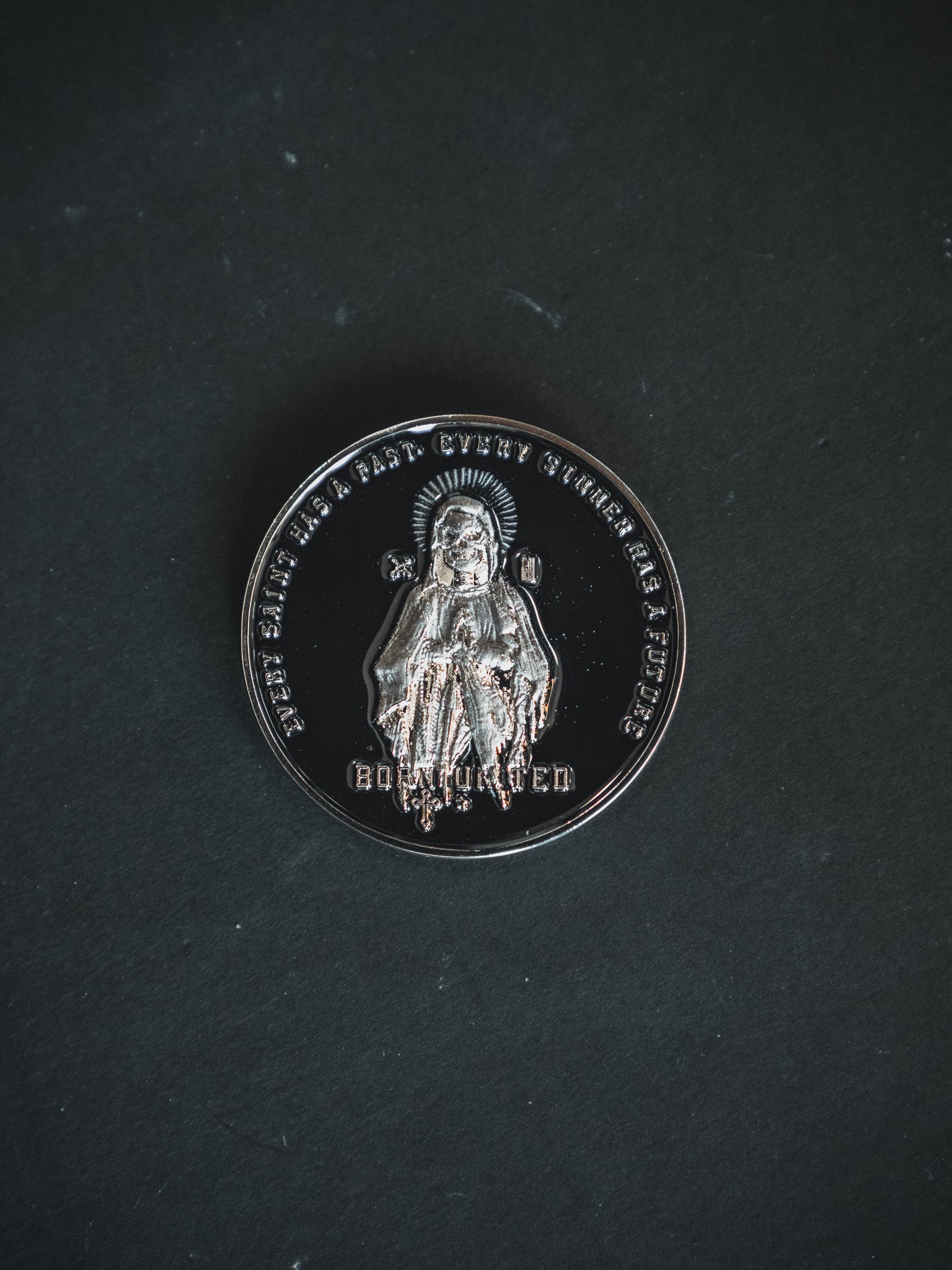 The Saints and Sinners Challenge Coin by Born United Private Label features an embossed medieval knight with a halo. BODVOCHED is carved below, with text encircling the edge. The coin rests on a dark background, blending past valor and future mystique.