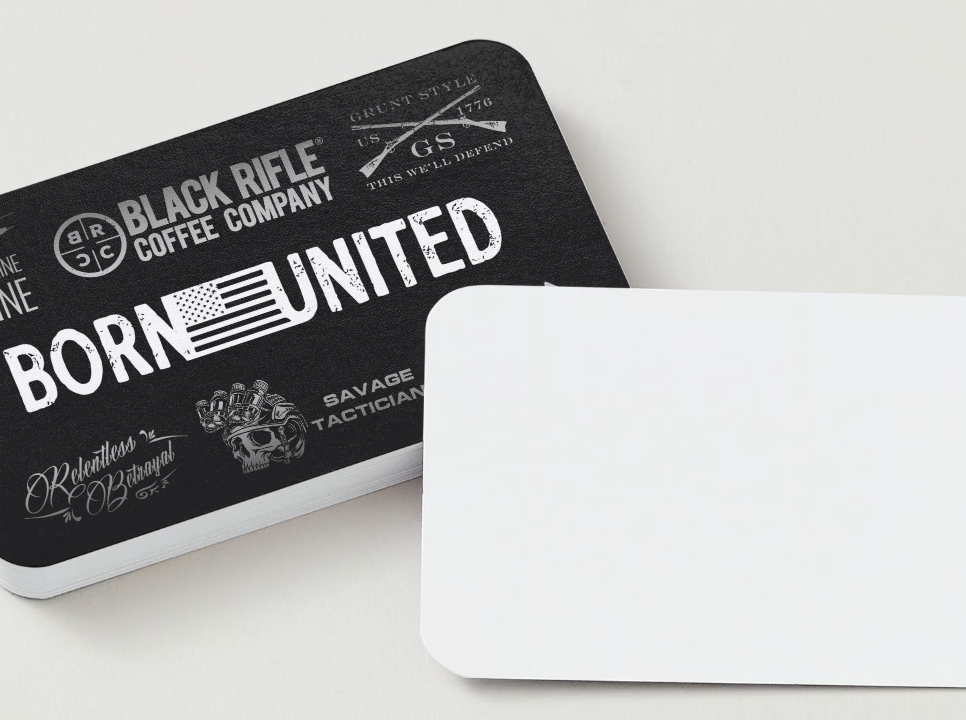 A stack of cards lies on the surface; the top card displays Gift Cards, featuring a stylized American flag and Born United. Below, the Born United Gift Card awaits, ready to brighten any patriots day.