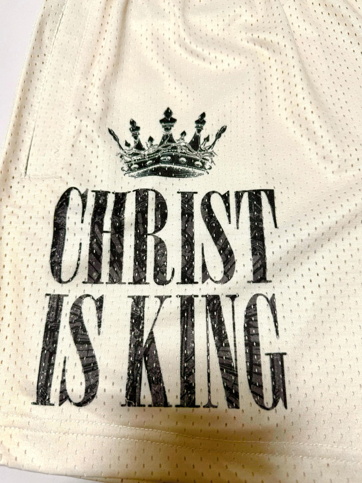 Step out in style with the 13th Men's Mesh Lifestyle Shorts | 5.5"- Christ is King Ivory—unisex ivory mesh athletic shorts featuring the bold statement "CHRIST IS KING" printed in black beneath a standout black crown graphic, perfect for making an impact both on and off the court.