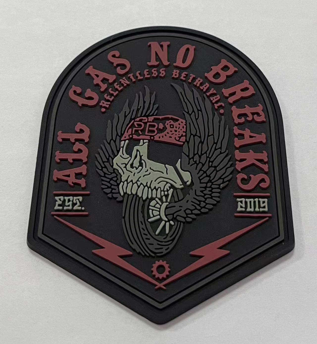An All Gas No Brakes PVC patch by Relentless Betrayal features a winged skull in a red cap with lightning bolt and gear motifs, mainly black and red, displaying EST. 2019 on the sides.