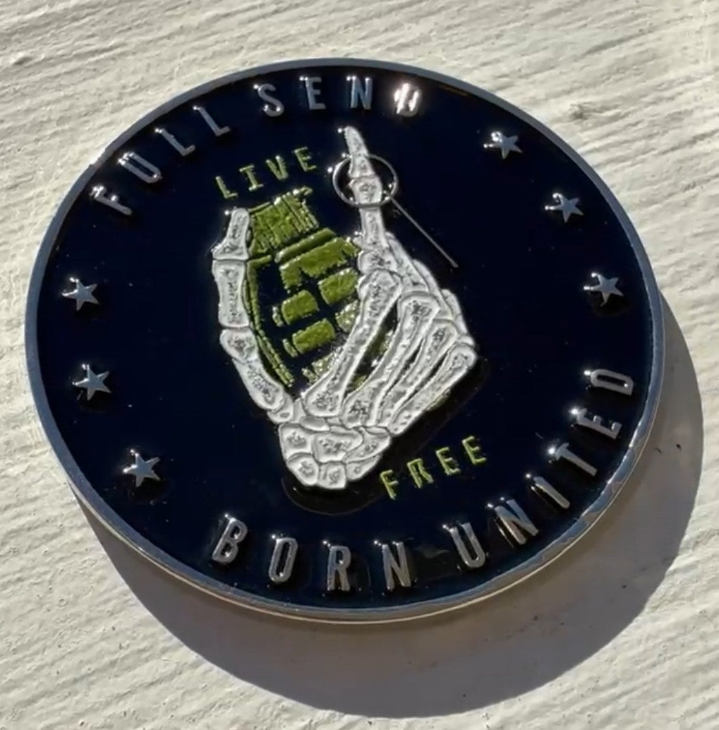 The Full Send Challenge Coin by Born United Private Label showcases a skeletal hand gripping a green grenade, encircled by FULL SEND and BORN UNITED on a round, shiny surface. Stars border the black backdrop, with shadows implying sunlight from the opposite side.