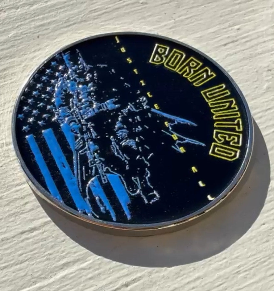 A round coin from Born United Private Label rests on a light surface, inscribed with the phrases BORN UNITED and JUSTICE WILL PREVAIL, featuring a soldiers image, an American flag with a blue stripe, and camouflage patterns. Its the Justice For All Challenge Coin.
