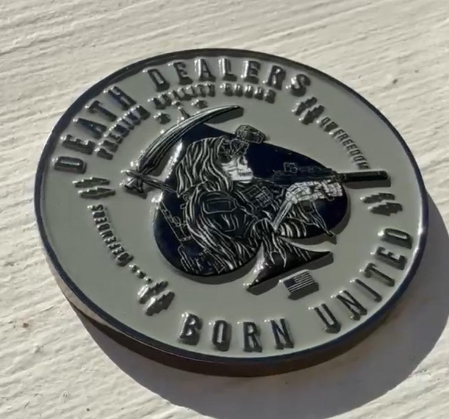 The Death Dealer Challenge coin by Born United Private Label is a military-style, round piece featuring a warrior with a rifle and scythe bearing Death Dealers and the elegantly inscribed phrase Born United, enhancing its striking design.
