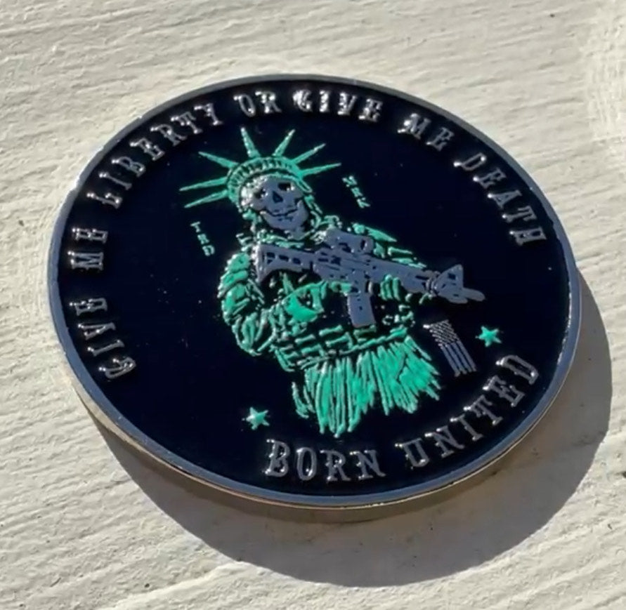 The Liberty Or Death Challenge Coin by Born United Private Label is round, featuring a raised Statue of Liberty with a rifle. It boldly states GIVE ME LIBERTY OR GIVE ME DEATH at the top and BORN UNITED at the bottom in striking green and silver.