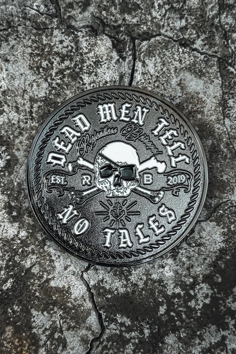 The Tell No Tales Challenge Coin by Relentless Betrayal is a round, silver piece with a skull and crossed swords boasting Dead Men Tell No Tales and Established 2019 RPG text. It rests on a cracked rocky surface for a rugged look, making it perfect for collectors wanting something unique.