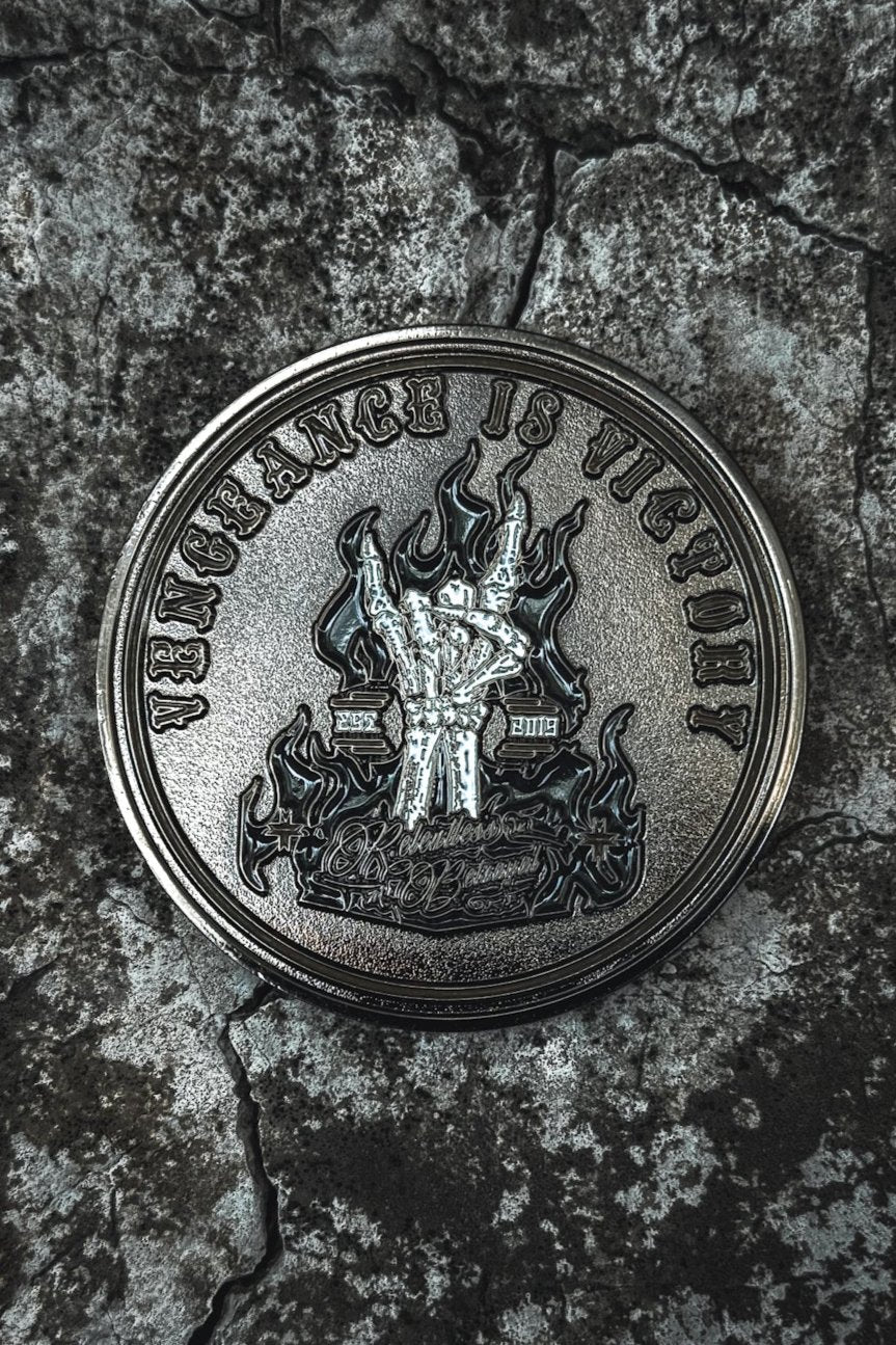 The Vengeance Challenge Coin by Relentless Betrayal features a warrior with a sword amid flames on cracked stone. The inscription Vengeance is Victory symbolizes resilience and empowerment.