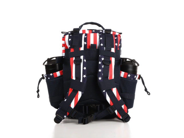 The Ultimate Patriot Special Edition Tac-Pac - 25L from Born United Private Label showcases an American flag design with red and white stripes, white stars on blue, plus multiple compartments and side pockets featuring black zippers.