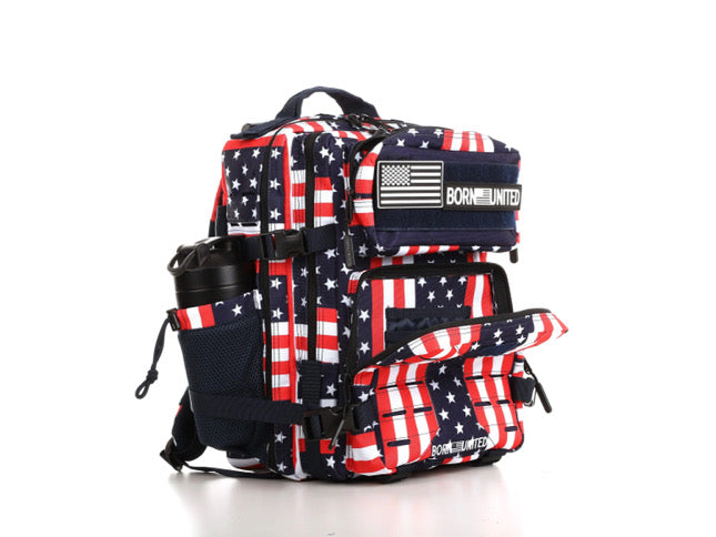 The Ultimate Patriot Special Edition Tac-Pac - 25L by Born United Private Label features an American flag-inspired design in red, white, and blue. It includes multiple compartments, adjustable straps, a front buckle, and a mesh side pocket for a water bottle. Its front displays Born United.