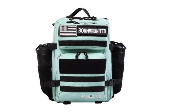 A Mint Condition Premium Tac-Pac - 25L by Born United Private Label, in light teal with black straps and multiple pockets, features an American flag patch and a BORN UNITED patch on the front, plus two side pockets for cylindrical items.