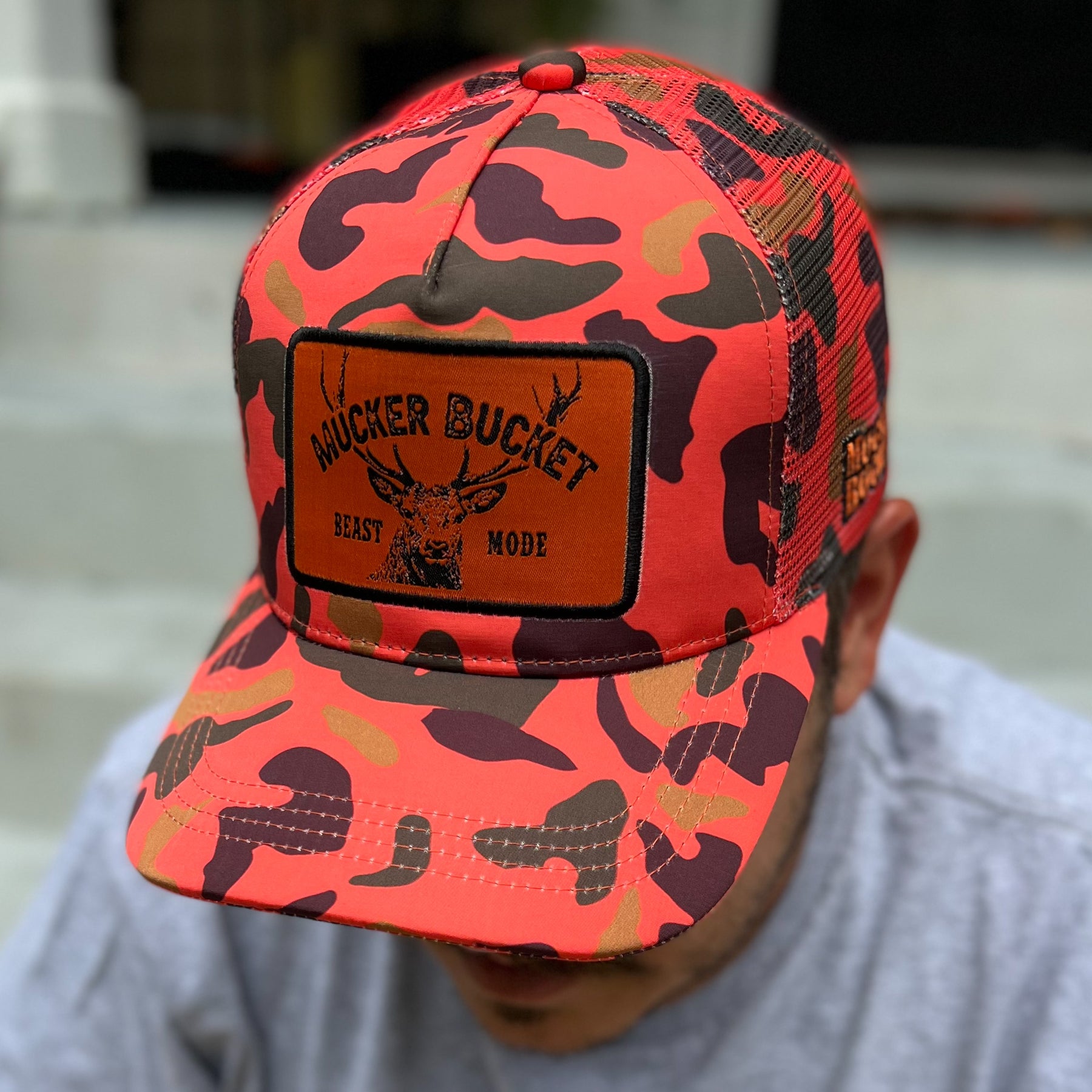 mucker bucket - "beast mode" orange camo trucker hat on model