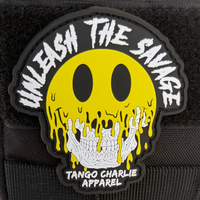 The black Velcro tear-away patch, Unleash The Savage by Tango Charlie Apparel, shows a melting yellow smiley face with a skull.