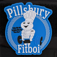 The Tango Charlie Apparel Pillsbury FitBoi Patch features a muscular dough figure in a chefs hat lifting weights, with the text Pillsbury Fitboi and playful subtitle Poke Me Man, Ya Make Him Say Hee Hee, set against a blue backdrop with white dots.