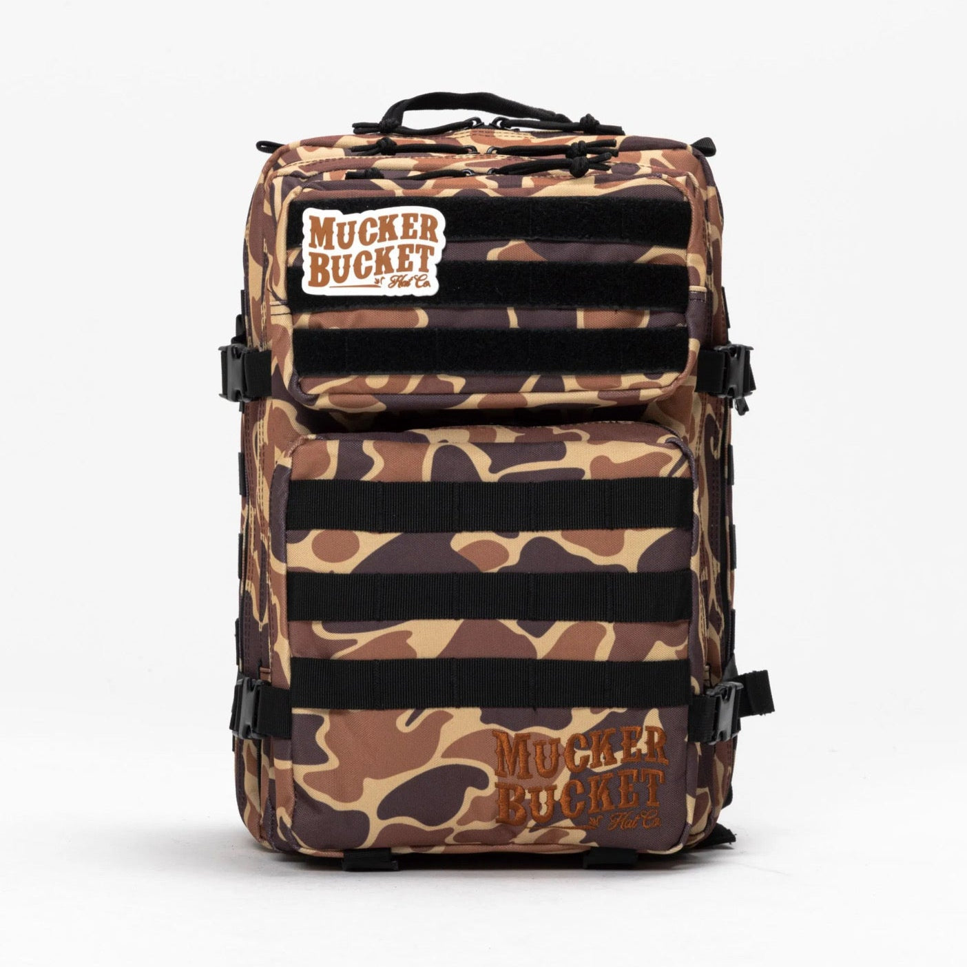 The Mucker Bucket Duck It Limited Edition Tac-Pac - 25L features a camouflage pattern, branded patches, and multiple straps and compartments—standing out against a plain white background.