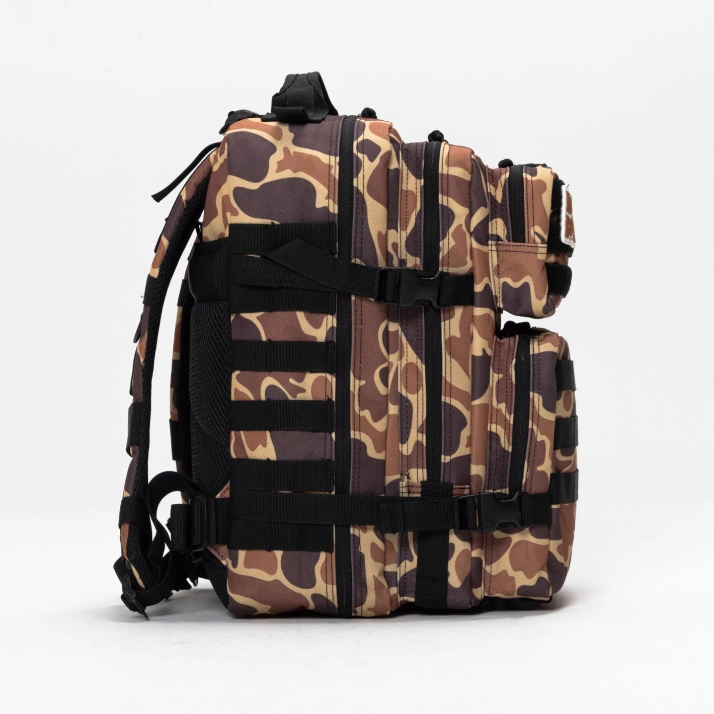 The Mucker Bucket Duck It Limited Edition Tac-Pac - 25L backpack, with camouflage pattern, multiple compartments, black straps, and sturdy buckles, stands upright on a white background—ideal for hunting and outdoor adventures.