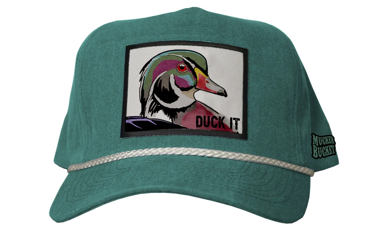 The Mucker Bucket Duck It - OG Green Wood Duck Bucket Hat features a colorful embroidered ducks head patch reading DUCK IT, with a white braided rope above the brim and a side tag labeled MUCKER F*CKER.