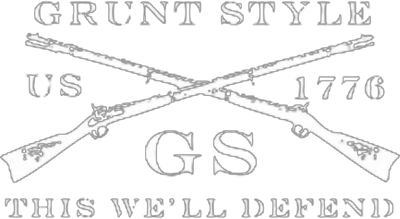 Logo with crossed muskets and text reading GRUNT STYLE at the top, US 1776 on the sides, GS in the center, and THIS WELL DEFEND at the bottom.