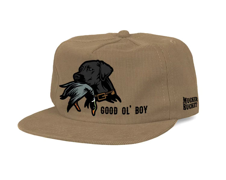 The Good Ol Boy Tan Corduroy cap by Mucker Bucket is a beige corduroy snapback featuring an embroidered black dog holding a duck with the text Good Ol Boy and Mucker Bucket on the side.