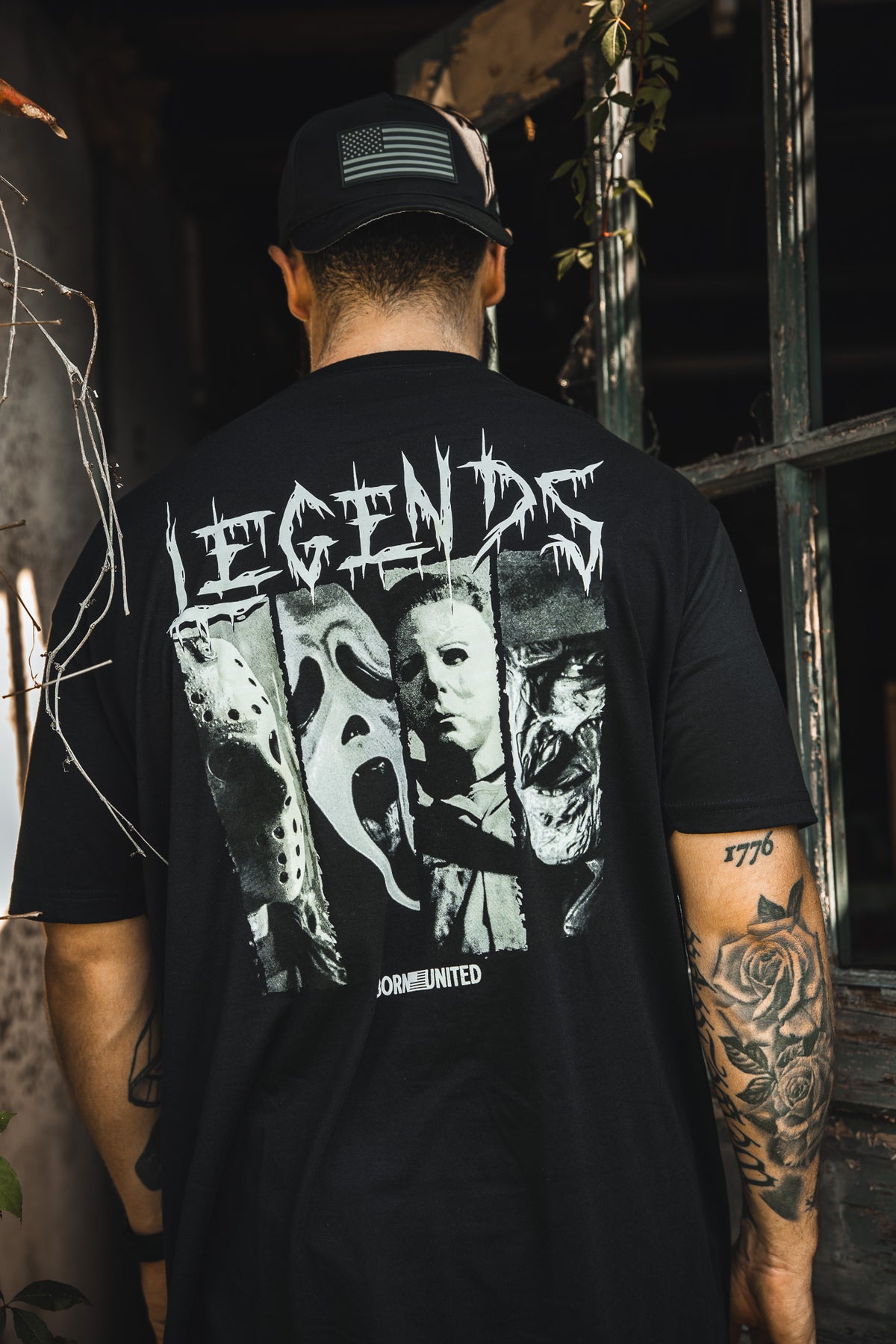 A person faces away from the camera, wearing the Born United Private Label "Legends of Fear" tee with black-and-white images of iconic horror movie characters and "LEGENDS" in bold, jagged lettering above them.