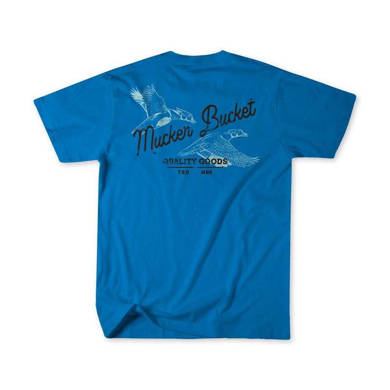 The Wood Ducks Premium Blue Tee by Mucker Bucket features Mucker Bucket on the back above flying ducks artwork and Quality Goods beneath, all in black and white. Made from premium cotton for comfort and durability.