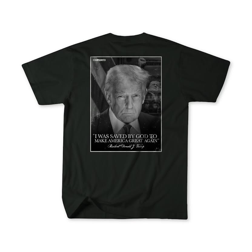 The black T-shirt, Legend - Saved by Born United Private Label, showcases a serious-looking man with the text I was saved by God to Make America Great Again. It subtly features part of the American flag as a backdrop, reflecting Donald Trumps campaign message.