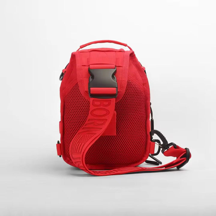 The Born United Private Label Red Reaper Tactical Sling-Pac - 4L features a bold red design, wide adjustable strap, mesh back panel, and large black buckle; shown upright against a white background for a stylish, functional look.