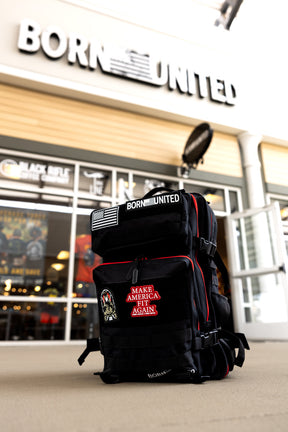 The Black Widow Premium Tac-Pac - 45L by Born United Private Label stands outside a store with a BORN UNITED sign above, featuring durable MOLLE webbing and a Make America Great Again patch.