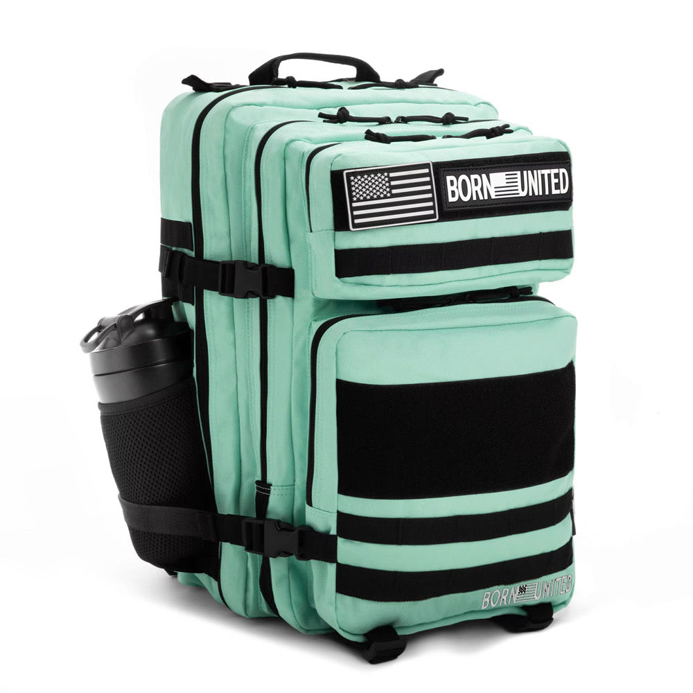 The Mint Condition Premium Tac-Pac - 45L by Born United Private Label is a mint green tactical backpack with black straps, a side water bottle pocket, American flag and BORN UNITED patches, plus multiple compartments and zippers.