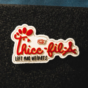 The Thicc-Fil-A patch by Tango Charlie Apparel parodies the Chick-fil-A logo with red text, “Thicc-fil-A” and “Lift Mor Weights,” plus a red paw print. Also available as a 3-inch Velcro patch.