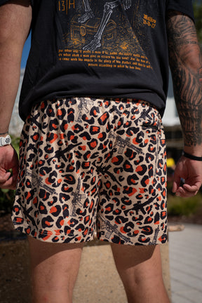 A person faces away outdoors in Tango Charlie Apparel’s Men’s Mesh Lifestyle Shorts | 5.5"- Loaded Leopard, styled with a black graphic tee and white wristwatch.