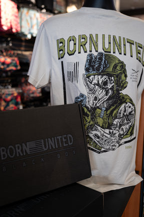 A mannequin wears a white Born United Private Label tee with a skull in military gear. In front, the Born United Black Box - TactiRhino from our Mystery Tees collection partially obscures the shirt.