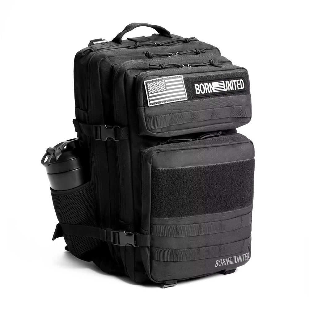 The Midnight Black Premium Tac-Pac - 45L by Born United Private Label features multiple compartments, two American flag patches, “BORN UNITED” text, and a water bottle in a side mesh pocket on a white background.
