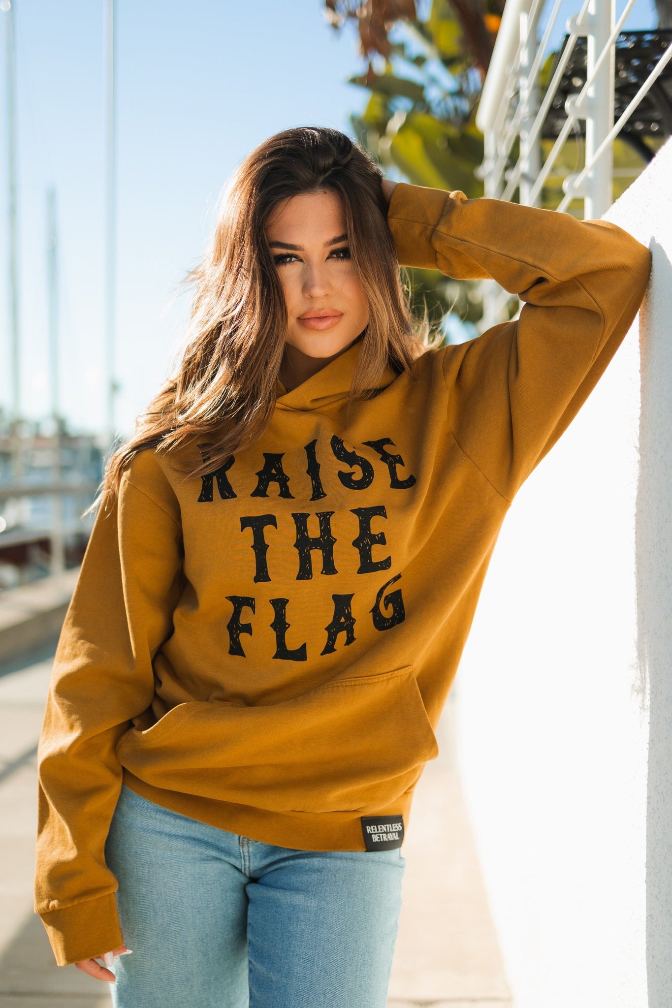 relentless betrayal - raise the flag premium toast hoodie front on women's model