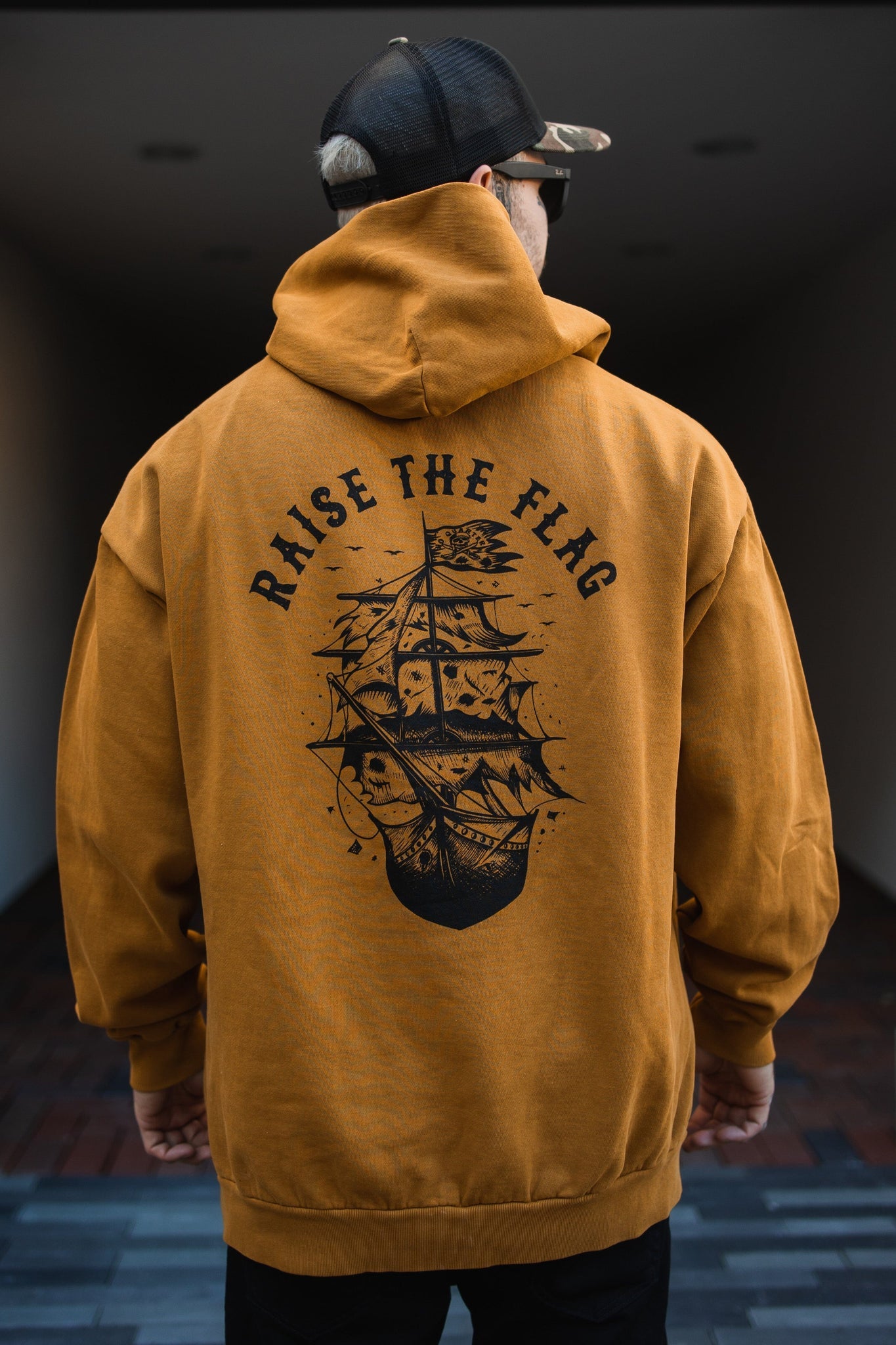 relentless betrayal - raise the flag premium toast hoodie back on men's model