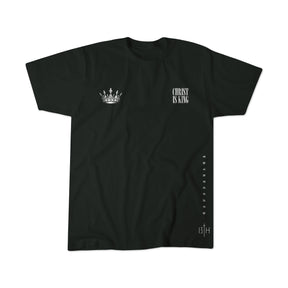 The Christ is King black T-shirt by 13th features striking white text proclaiming its name on the front, along with a crown logo, vertical side text, and a 13TH marking at the bottom. Its simple yet bold design celebrates faith with regal elegance.