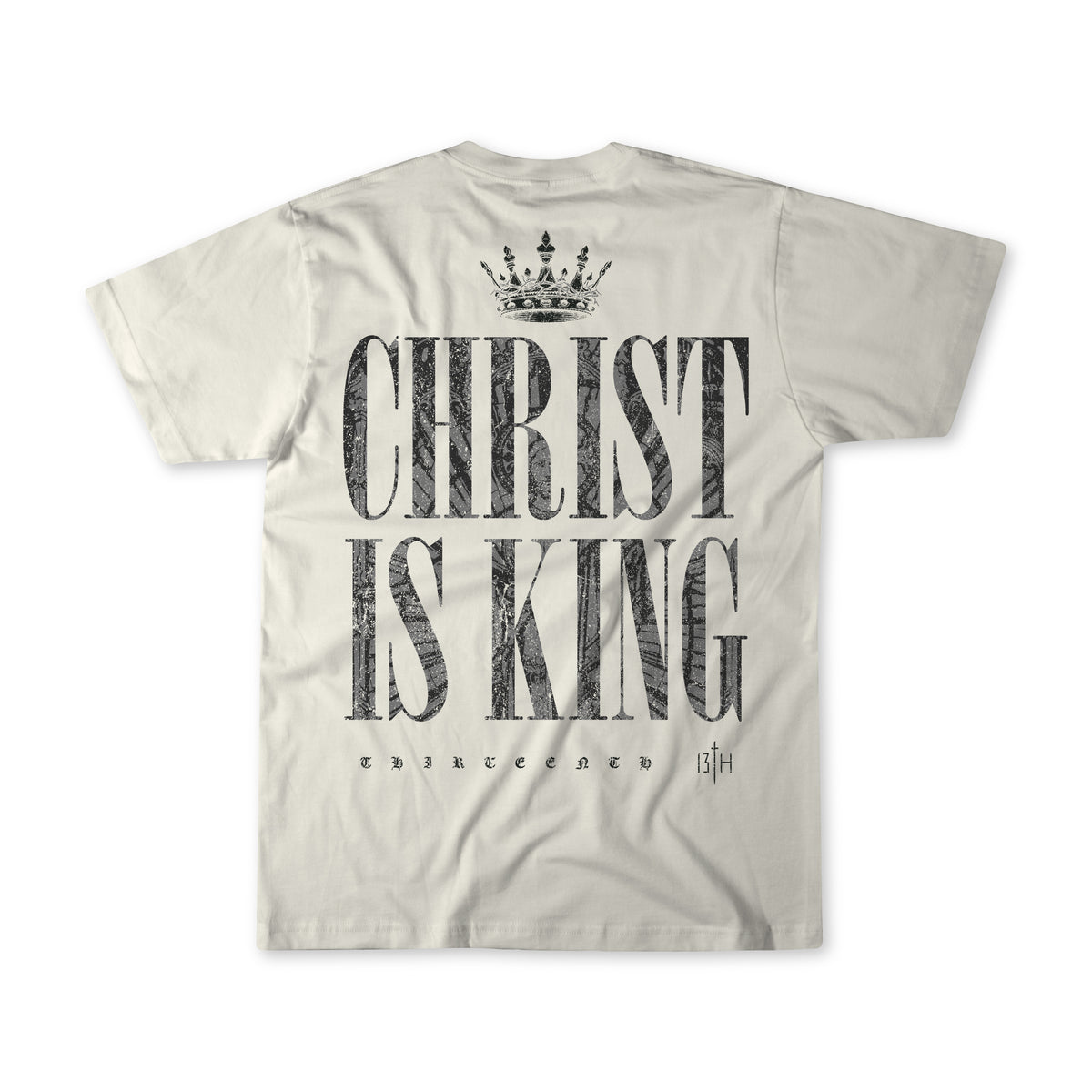 The Christ is King - Ivory T-shirt by 13th features a crown graphic above bold CHRIST IS KING text with THIRTEENTH 13|H below—a premium tee perfect for making a faith-filled statement.