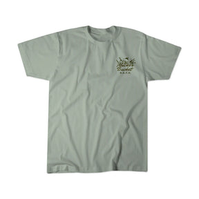 DAFO Premium Tee by Mucker Bucket in gray-green, features The Micker Bucket D.I.F.O. text and palm tree graphic on the upper left chest, displayed flat against a white background.