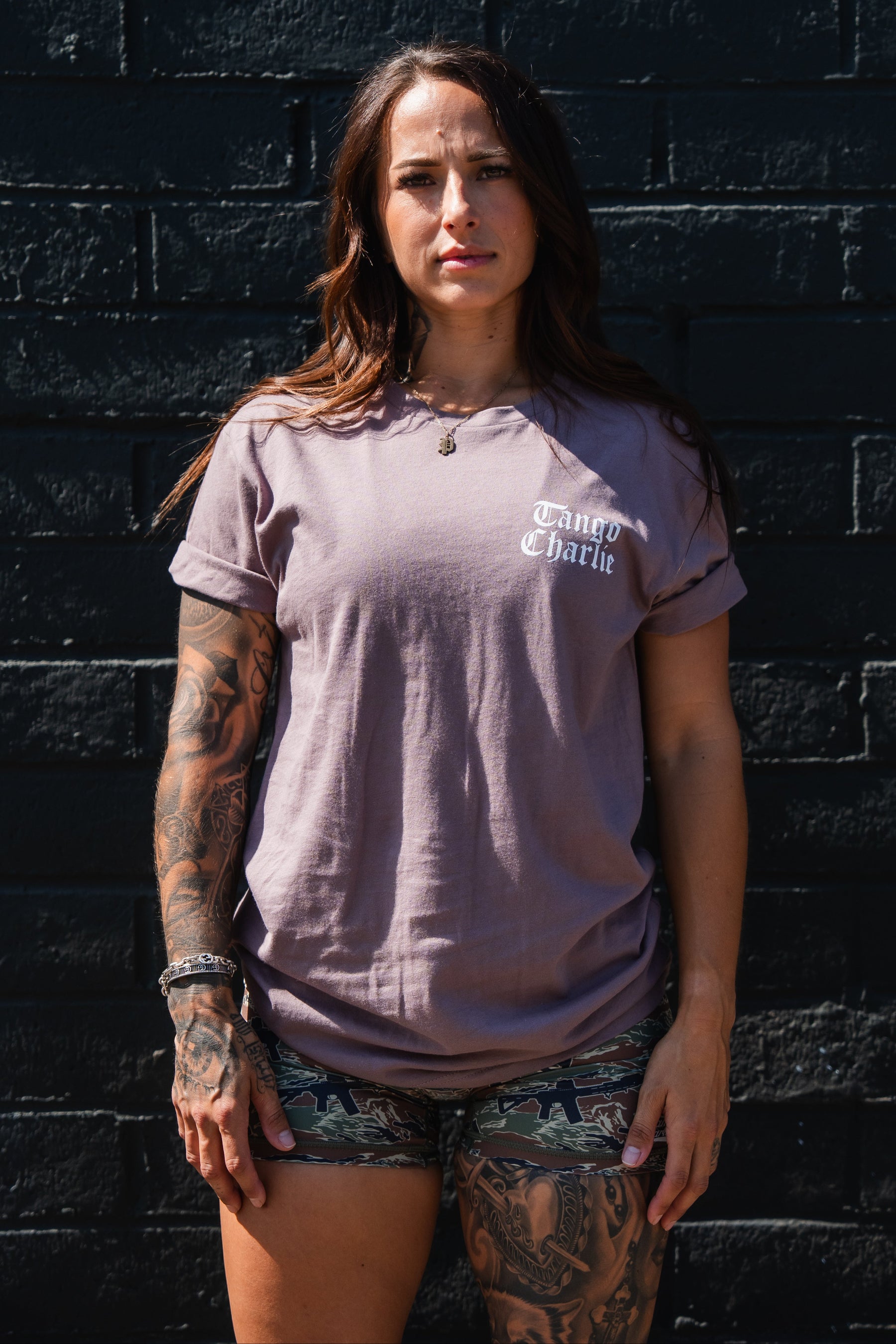 A person wearing a dusty purple short-sleeved Lift Heavy. Praise Hard. Shiitake Tee with Lift Heavy, Praise Hard printed in white text on the chest.